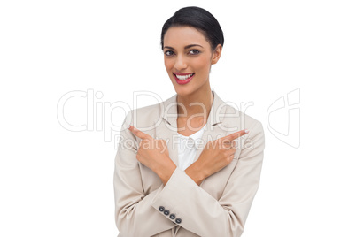 Cheerful businesswoman with her arms crossed and fingers pointin