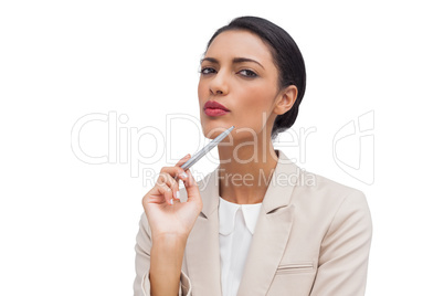 Thoughtful young businesswoman holding a pen