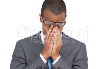 Young businessman with glasses holding his head between hands