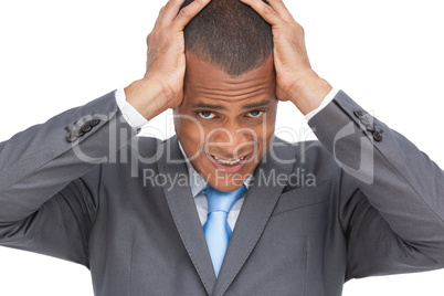 Exhausted businessman holding his head between hands
