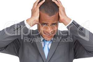 Exhausted young businessman holding his head between hands