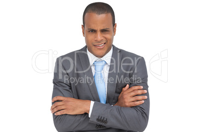 Doubtful young businessman with arms crossed