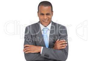 Doubtful young businessman with arms crossed