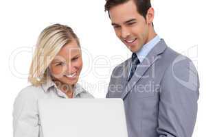 Business people looking at laptop and smiling