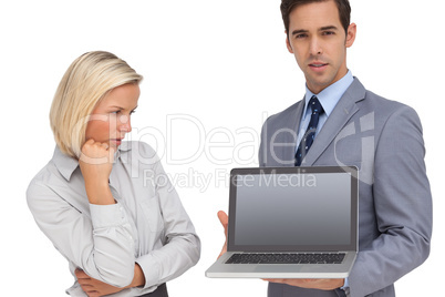 Businesswoman looking at colleagues laptop