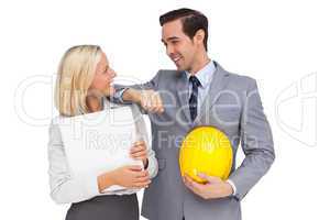 Architects with plans and hard hat smiling at each other