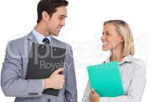 Smiling business people looking at each other with folders