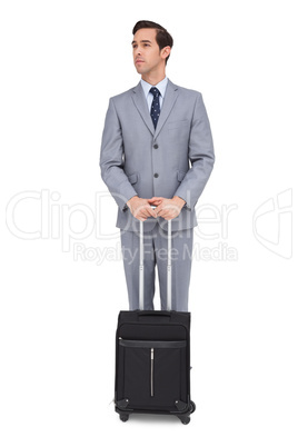 Serious businessman waiting with his luggage