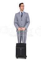 Serious young businessman waiting with his luggage