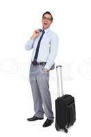 Laughing businessman standing next to his suitcase