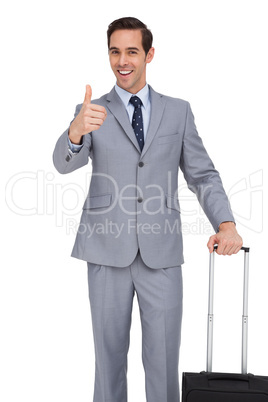 Smiling businessman with suitcase showing his thumb up