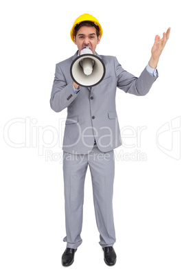 Architect with hard hat shouting with a megaphone