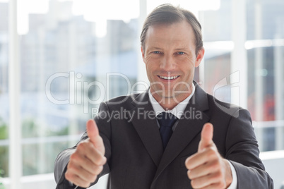 Smiling businessman giving thumbs up