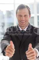 Smiling confident businessman giving thumbs up