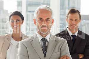 Businessman standing with colleagues behind