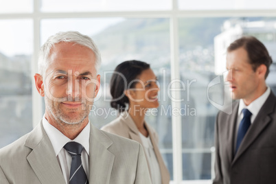 Businessman standing in front of colleagues speaking together