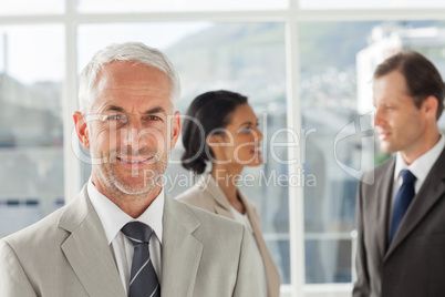 Confident businessman standing in front of colleagues speaking t