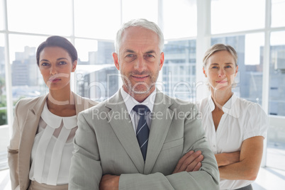 Confident businessman standing in front of colleagues