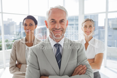 Smiling businessman standing in front of colleagues