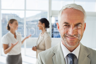 Smiling businessman standing in front of colleagues