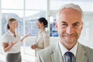 Smiling businessman standing in front of colleagues