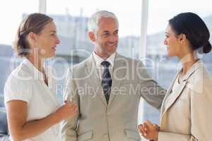 Likeable businessman speaking with female colleagues