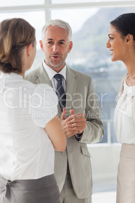 Mature businessman discussing with female colleagues