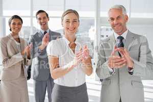 Smiling business people applauding together