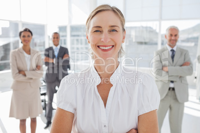 Cheerful businesswoman standing with arms folded