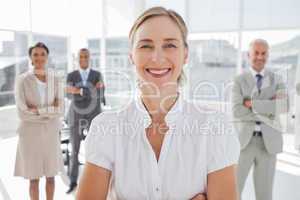 Cheerful businesswoman standing with arms folded