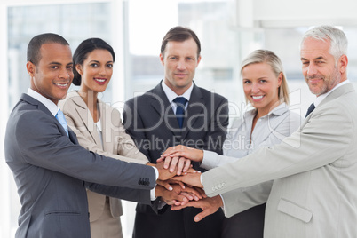 Group of business people piling up their hands together