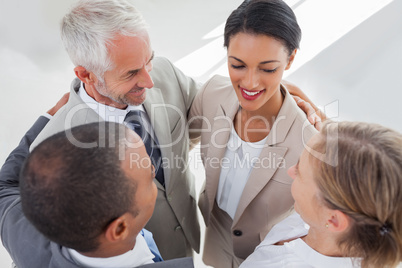 Smiling business people embracing together