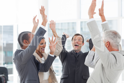 Group of smiling business people raising their hands