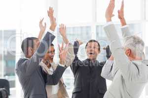 Group of smiling business people raising their hands