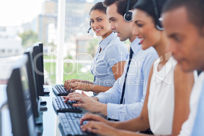 Smiling call centre employees working on computers Smiling call centre employees working on computers