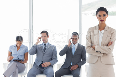 Businesswoman standing in front of business people