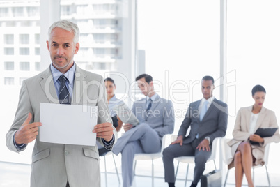 Serious businessman holding a blank notice