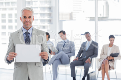 Smiling businessman holding a blank sign