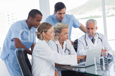 Serious medical team using a laptop