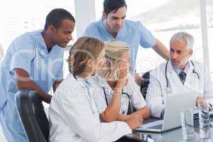 Smiling medical team using laptop