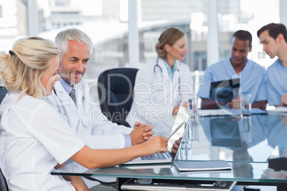 Two smiling doctors using laptop