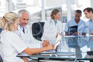 Two smiling doctors using laptop