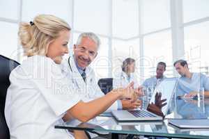 Two smiling doctors looking at a laptop