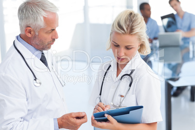 Two doctors holding a blue file