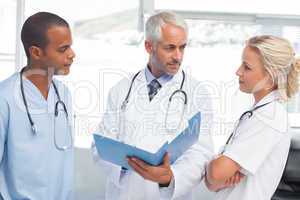 Three doctors examining a file