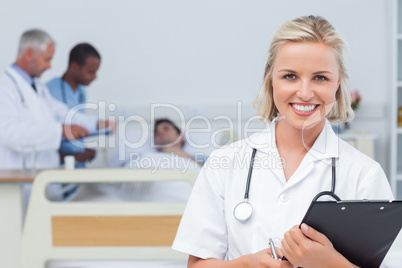 Nurse holding clipboard and looking at the camera