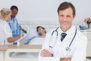 Smiling doctor standing and looking at the camera