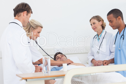 Medical team taking the heartbeat of a patient Medical team taking the heartbeat of a patient