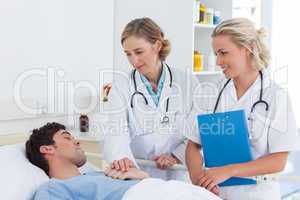 Two women doctors taking care of a patient
