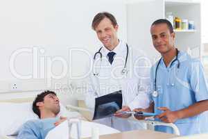 Doctors with radiography standing next to a patient